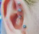 Flower shaped stoned tragus penetration with other matching ear piercings